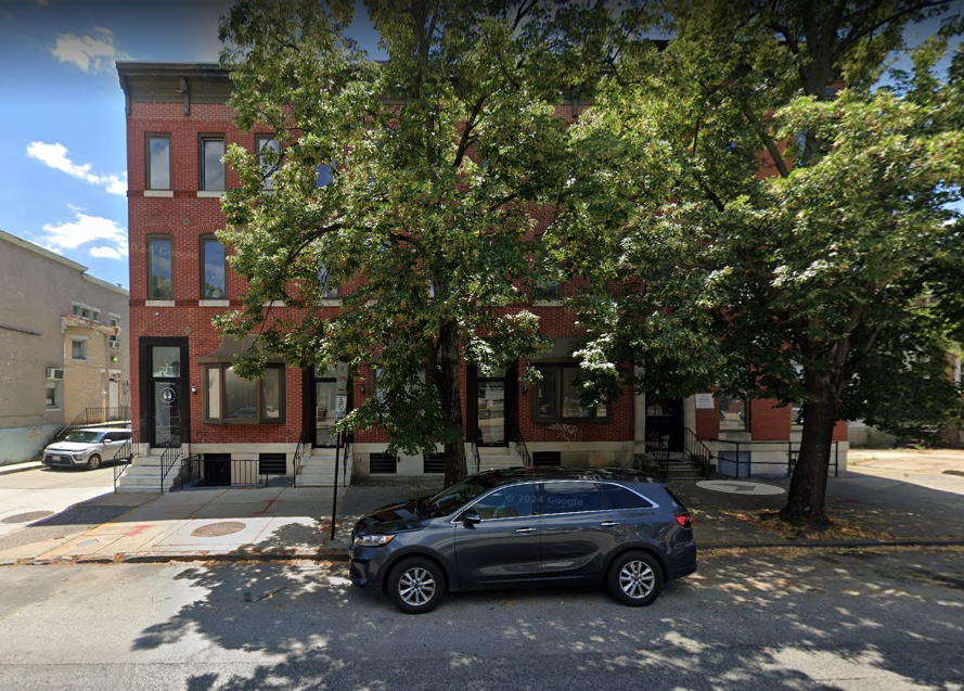 Red brick building with large trees in front of Recovery Center of Maryland