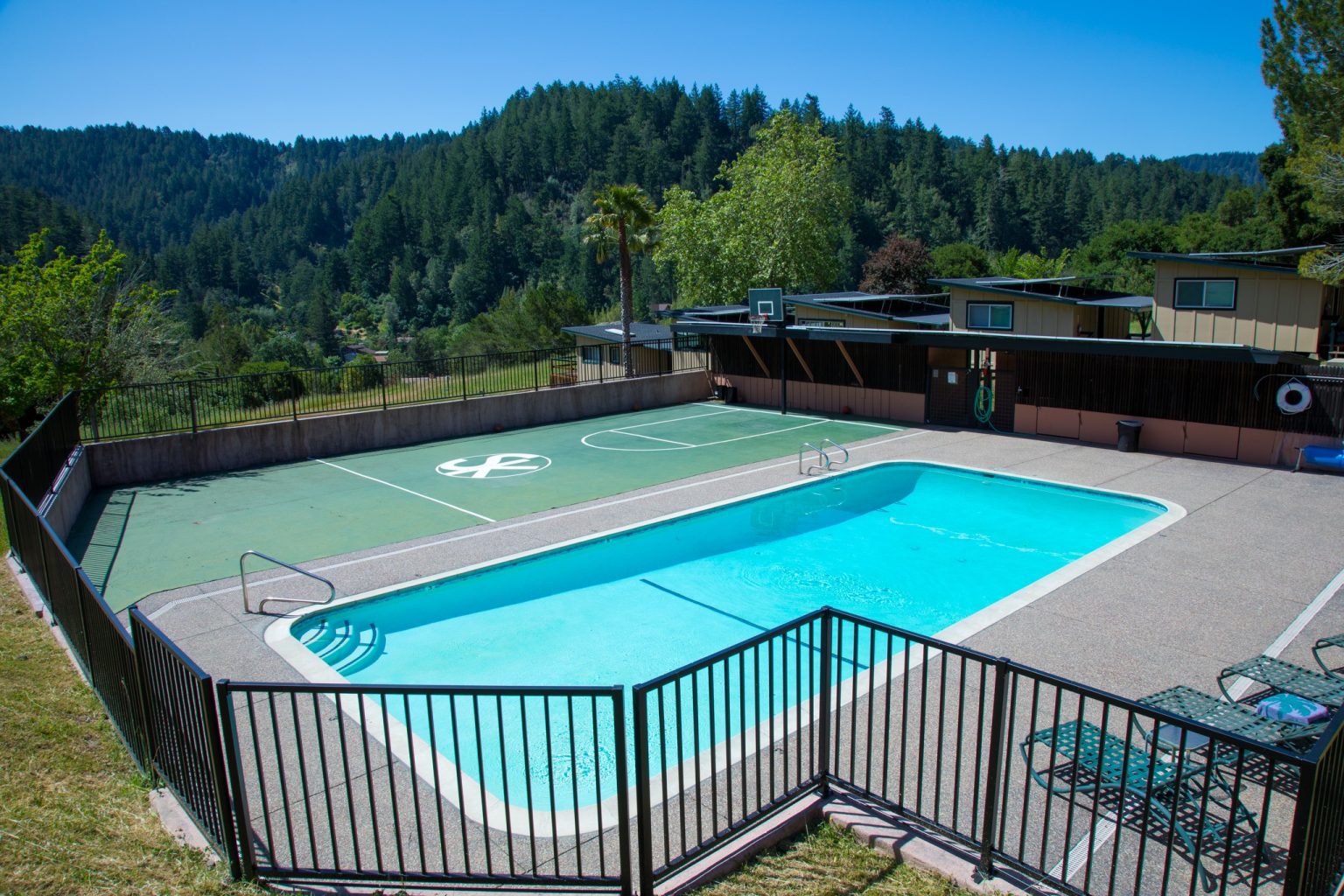 Outdoor swimming pool beside basketball court