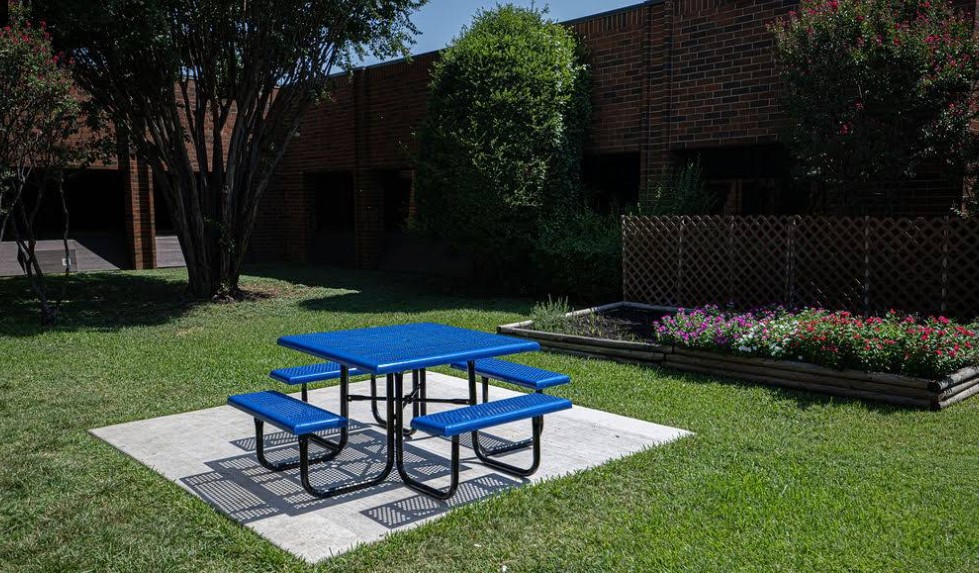 Outdoor patio with picnic table and landscaped lawn