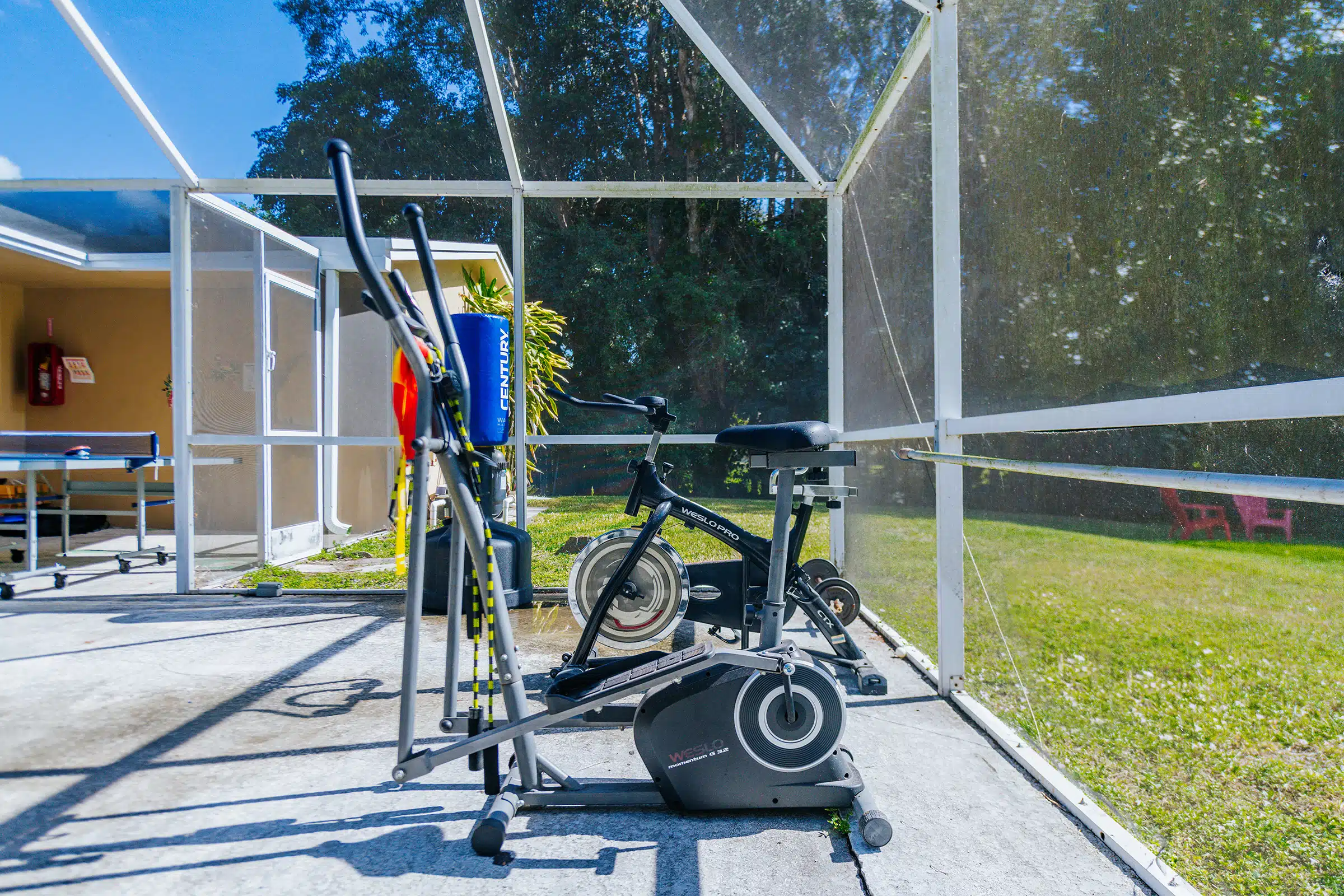 Exercise bike and elliptical on a screened patio