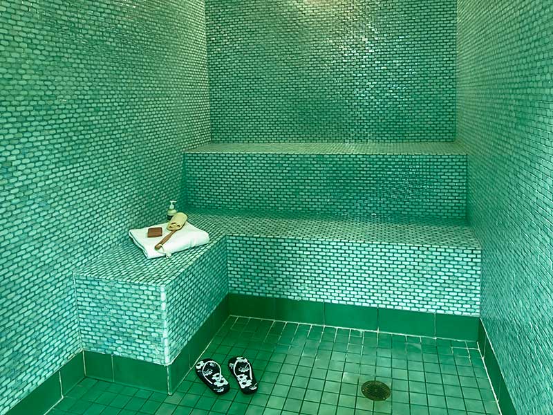 Tiled steam room with bench seating and spa-like atmosphere