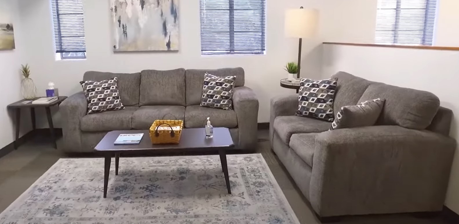 A cozy lounge with gray sofas, a coffee table, and decorative pillows