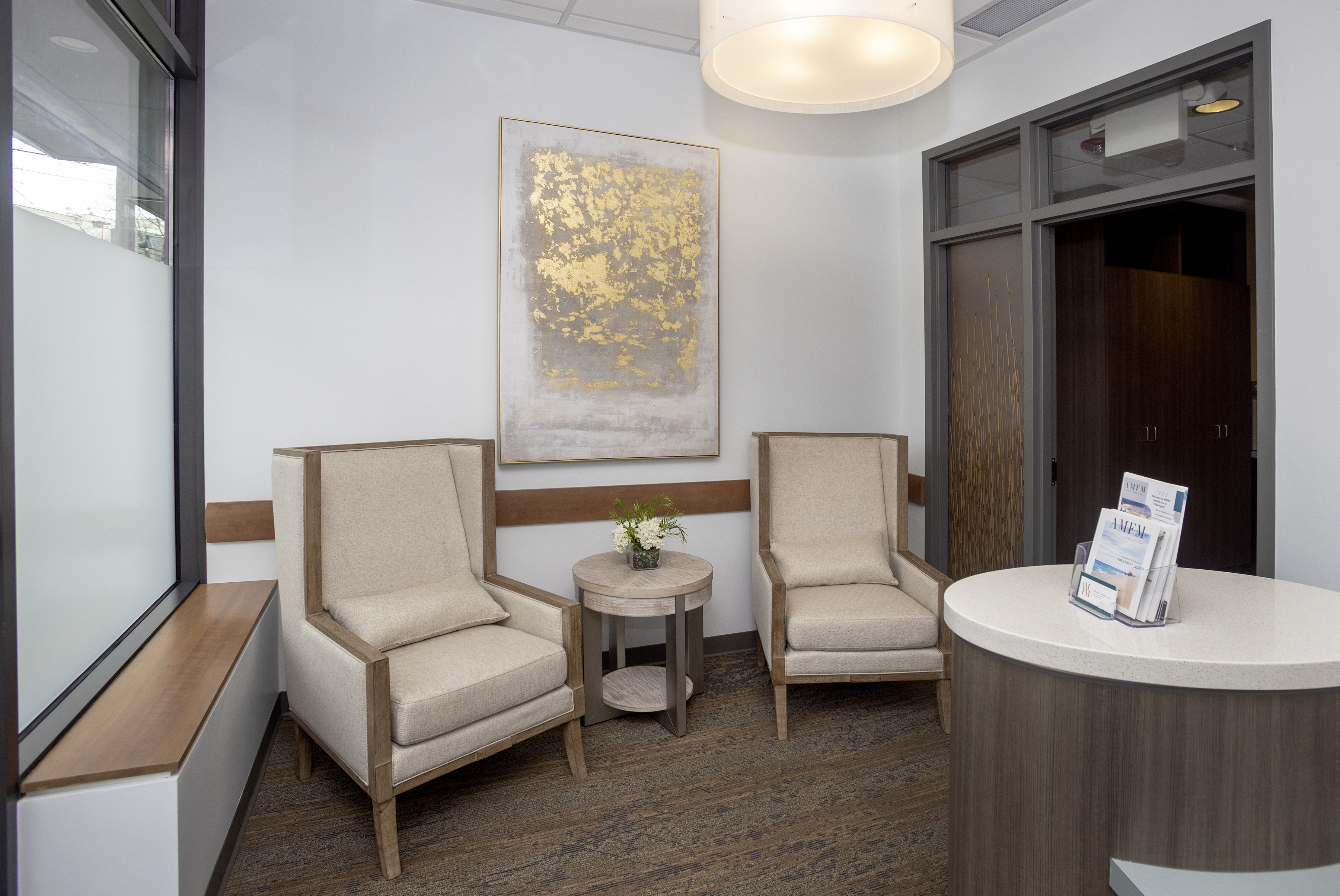 Two high-back chairs near a window and round table