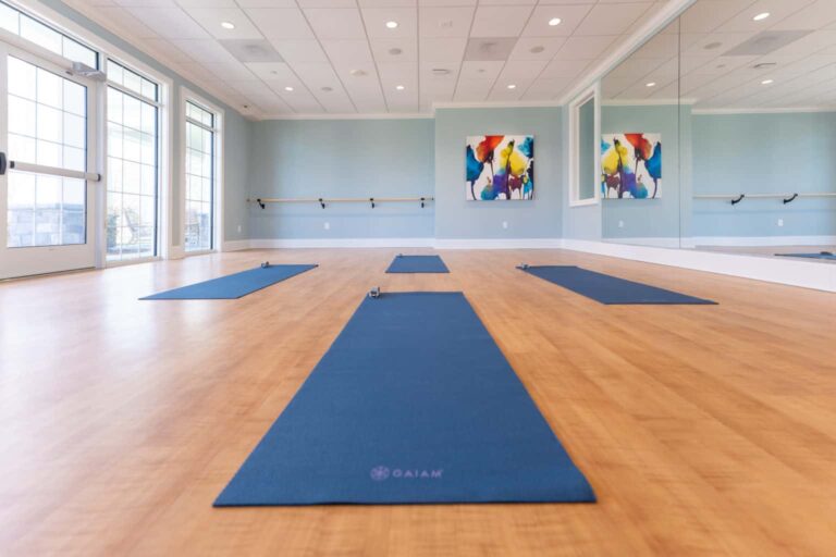 Yoga studio with mats, mirrored wall, and natural light