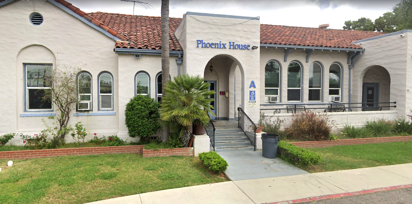 Entrance of Phoenix House with sign and palm tree landscaping