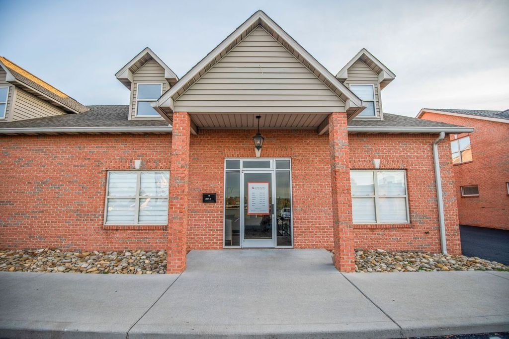 Brick building with glass entryway and sign above door