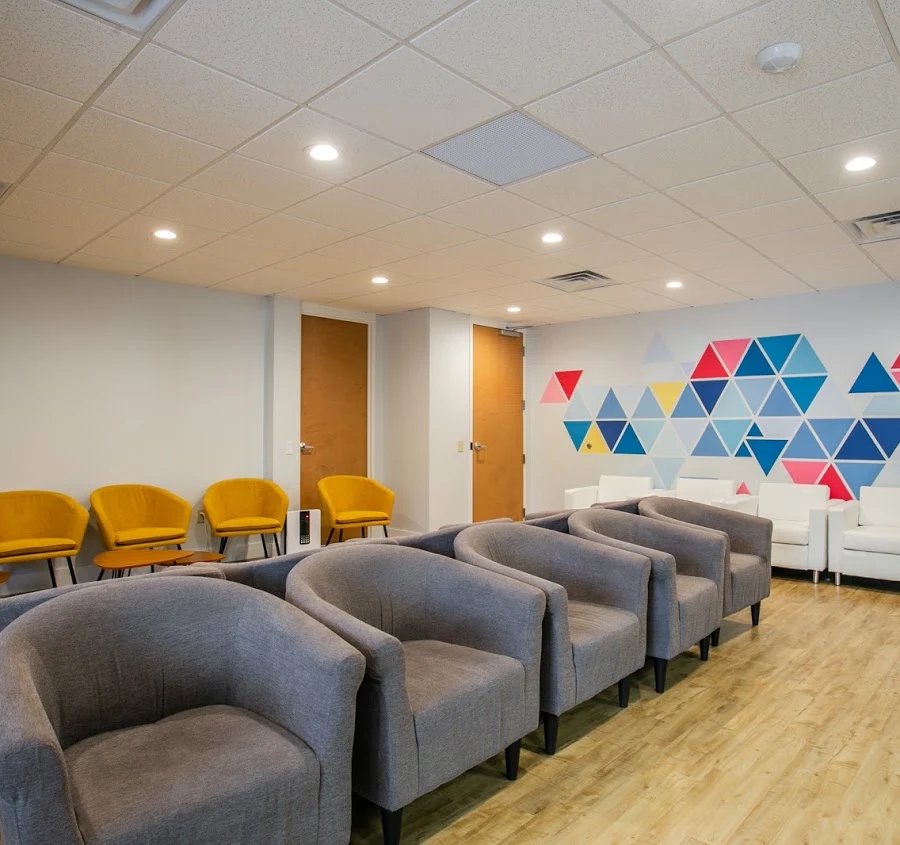 Waiting area with rows of gray, yellow, and white chairs
