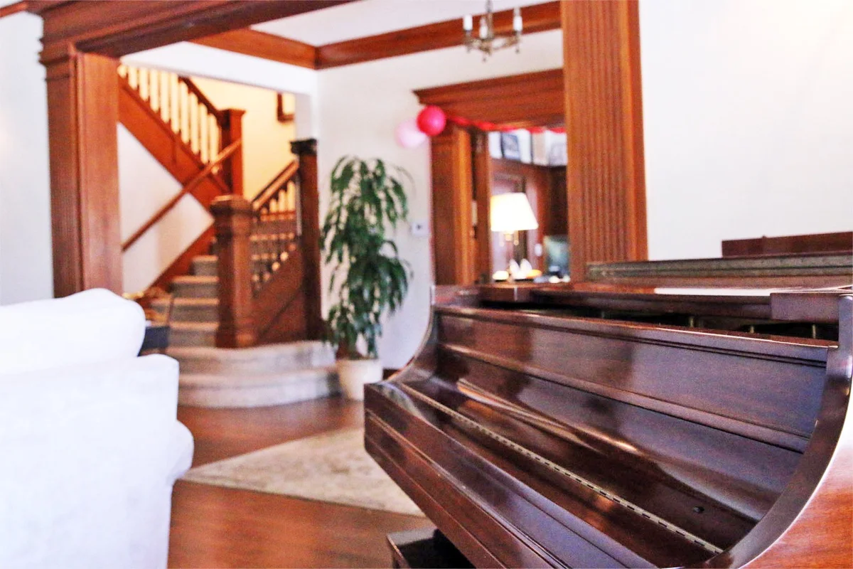 Piano and elegant staircase inside Friendly House Los Angeles