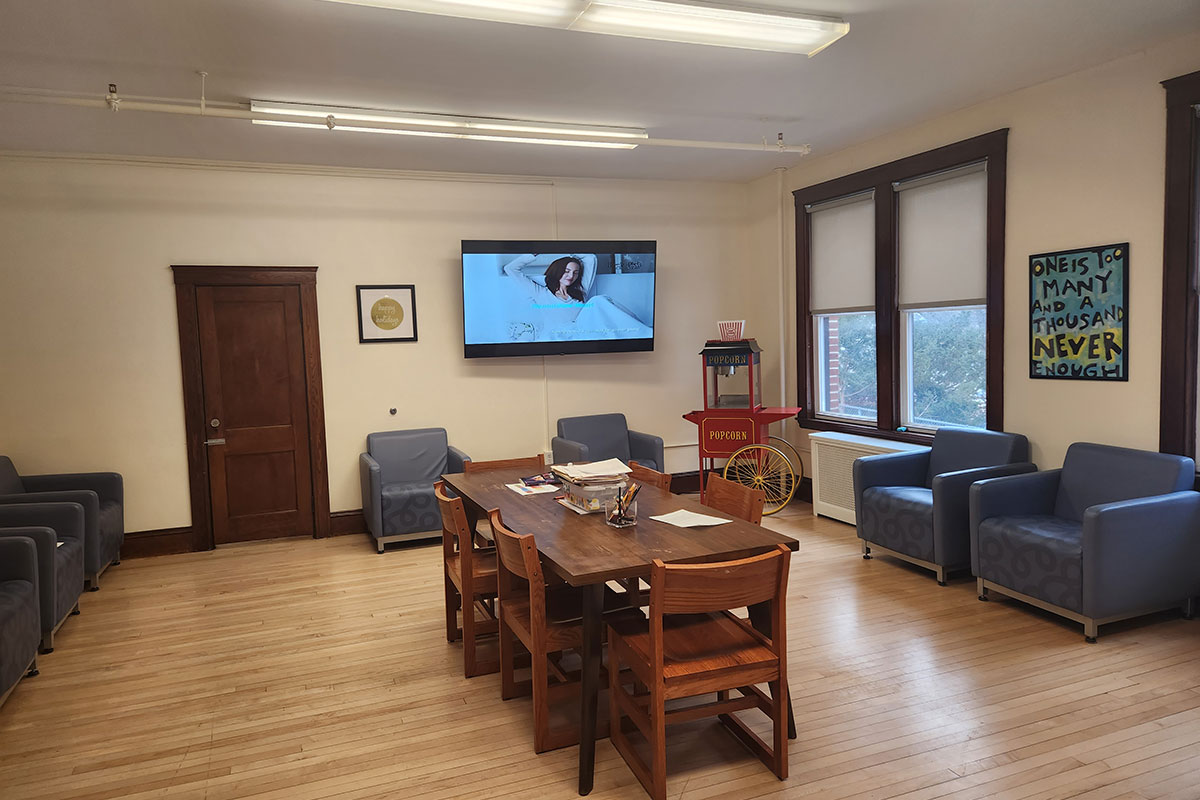 Lounge with chairs, TV screen, and popcorn machine