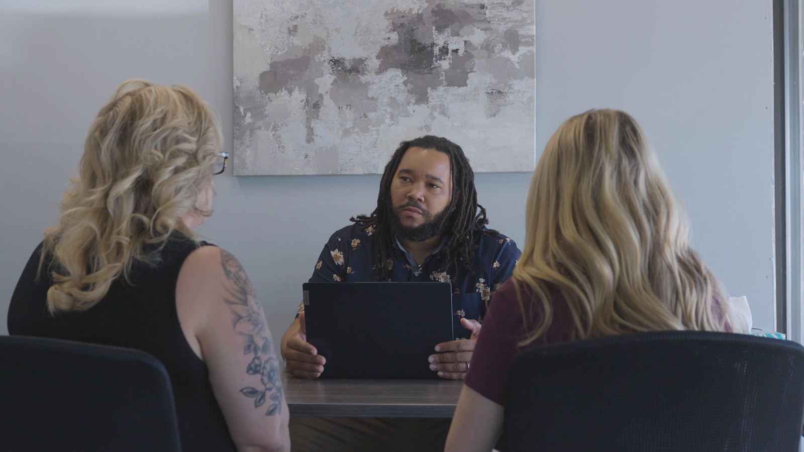 A counselor meeting with two clients.