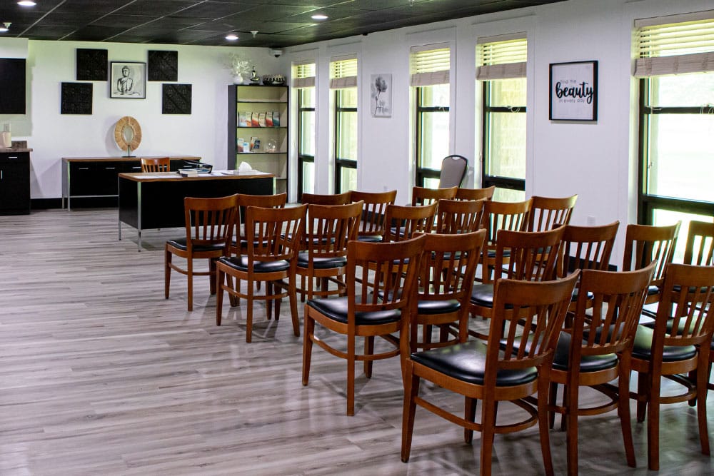 Wood chairs arranged in a group setting with windows