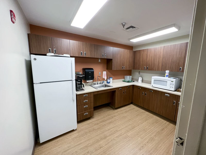 Shared kitchen with refrigerator, microwave, sink and cabinets