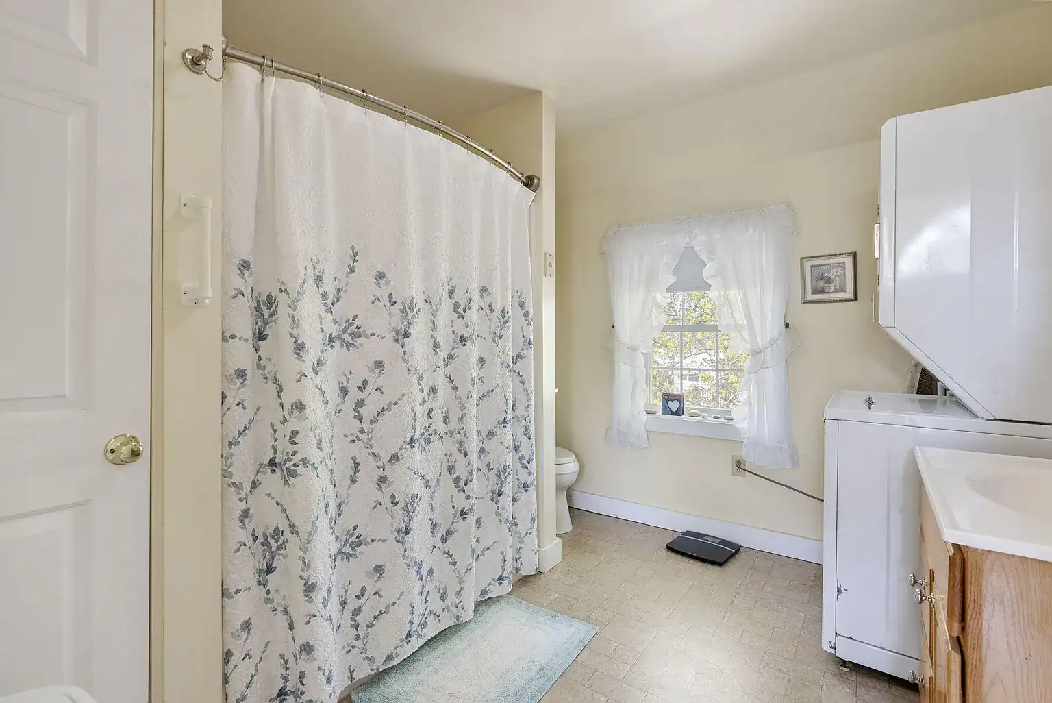 Spacious bathroom with walk-in shower and in-unit laundry facilities at Southern Maine Recovery