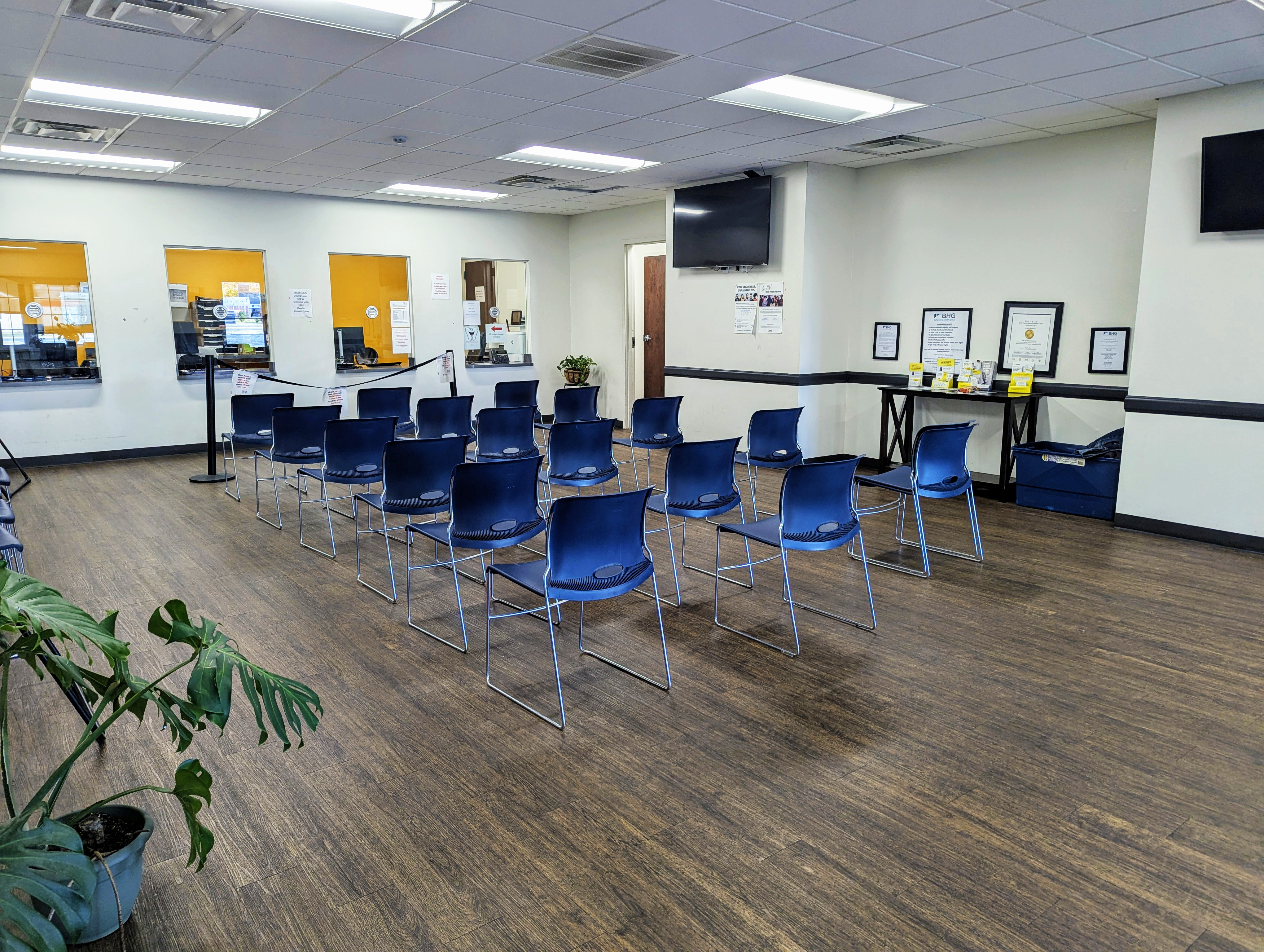 Patient seating facing check-in windows and information table