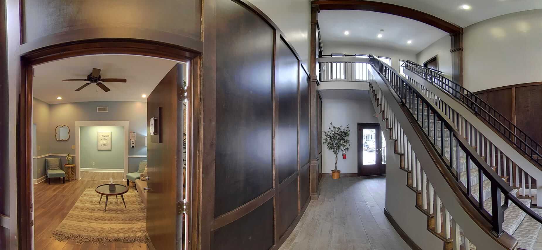 Elegant entry hall with staircase and lounge view