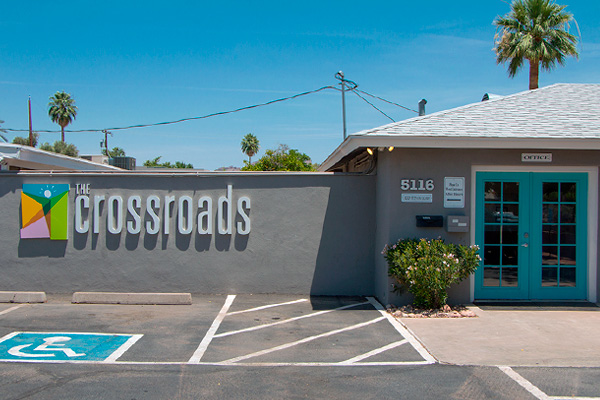 Exterior view of Crossroads Arcadia building with gray walls and turquoise door