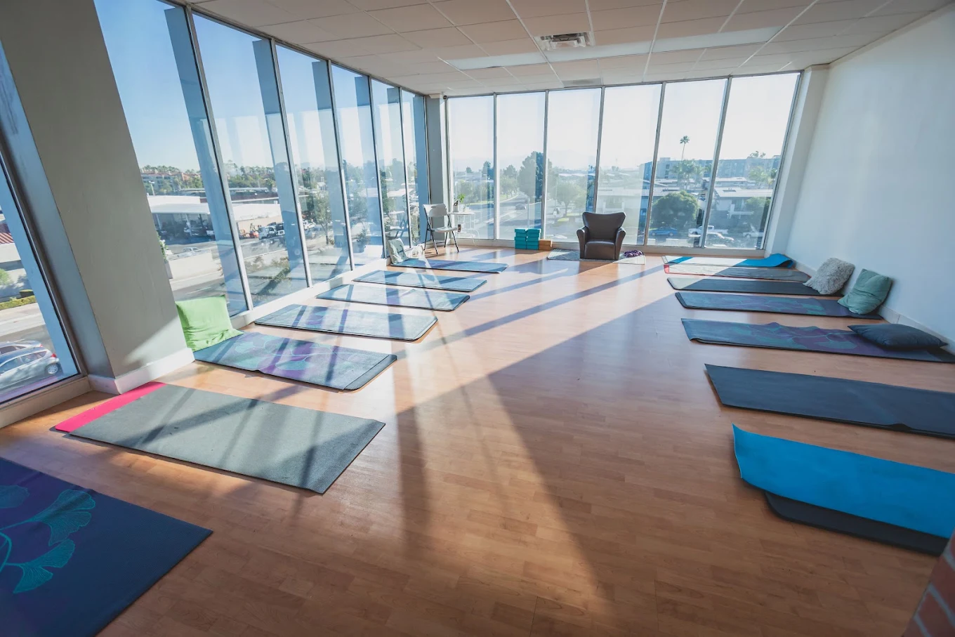 Bright yoga room with mats and floor-to-ceiling windows
