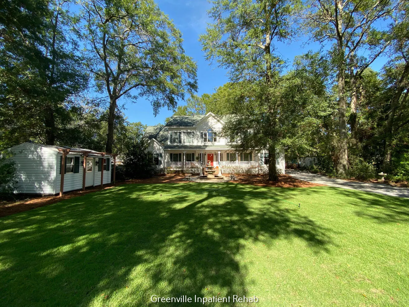 Rehab house with large lawn and tall trees