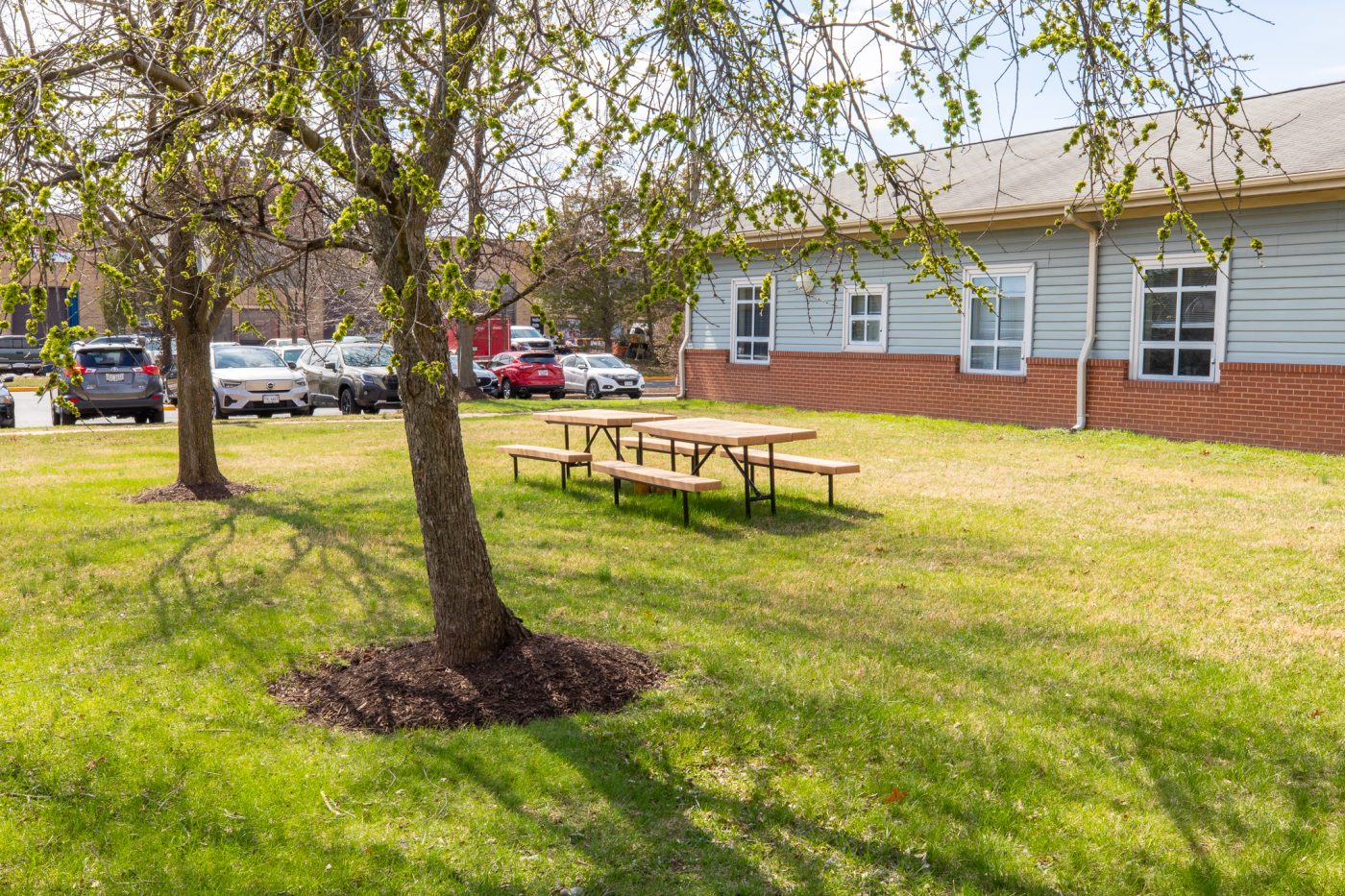 Picnic tables on grassy lawn beside treatment center