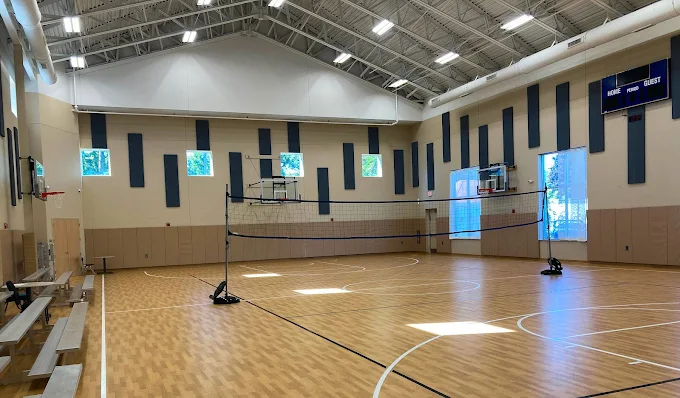 Indoor gym with basketball hoops and volleyball net